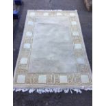 A rectangular thick pile wool rug, the fawn field framed by greek key style border. (73in x 49in)