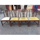 A set of four Hepplewhite style mahogany dining chairs, the arched backs carved with harebells above
