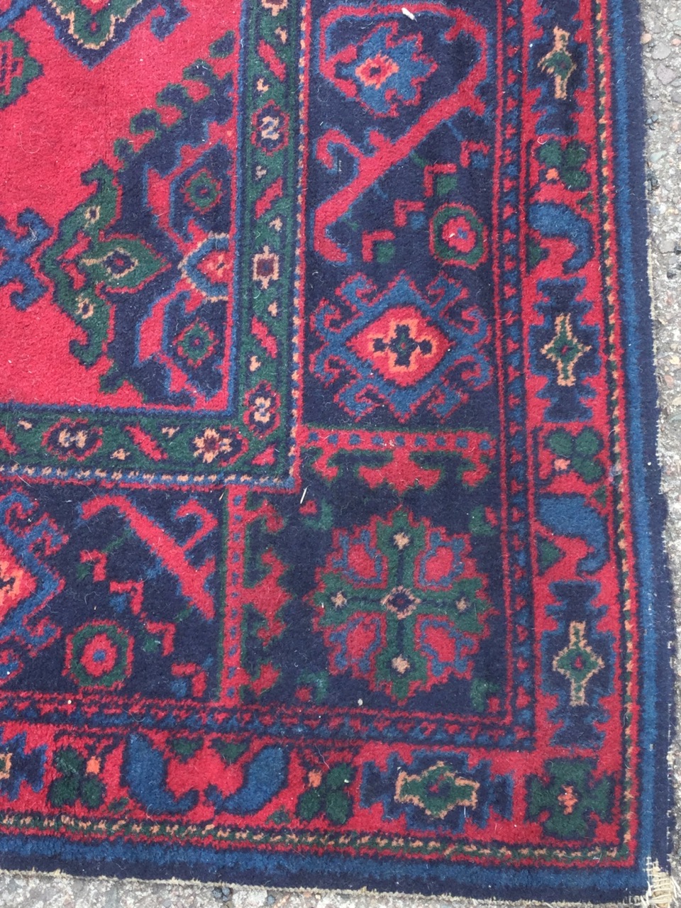 A Turkish carpet woven in the traditional green & blue palette on red ground - some wear. (124in x - Image 2 of 3