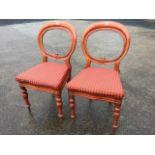 A pair of Victorian mahogany balloon back dining chairs, the moulded ovals with scrolled carving