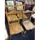 A set of four late Victorian elm seated kitchen chairs with spindle backs beneath arched rails above