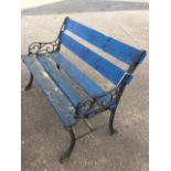 A small slatted garden bench with scrolled cast iron ends on sabre legs. (39.5in)