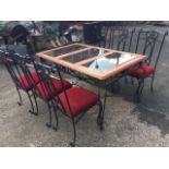 A wrought iron conservatory table with six dining chairs, the table with hardwood top having three