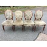 A set of four Victorian mahogany ballon-back dining chairs with button upholstered panels in oval