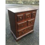 A Georgian oak spice chest, with crossbanded top above three small, two short and one long drawer,