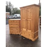 A reproduction pine wardrobe and chest of drawers, the robe with moulded cornice above fielded