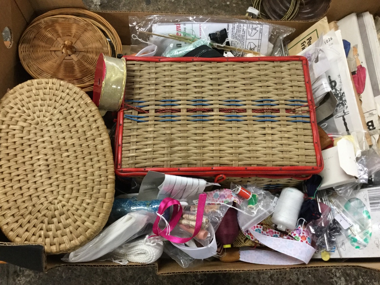 A box of miscellaneous sewing materials including buttons, cottons, beads, sewing baskets,