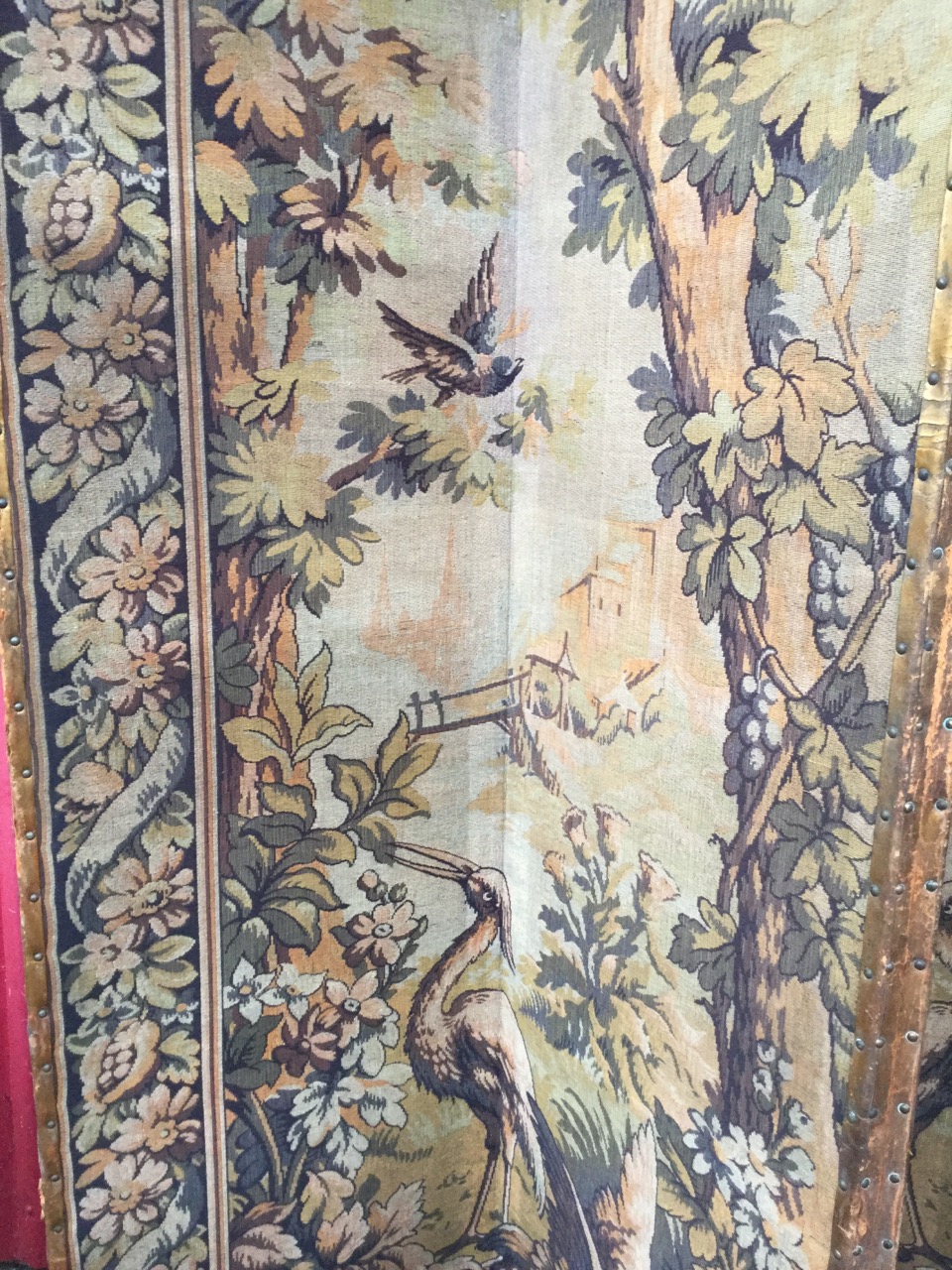 A tall four-fold antique tapestry screen, the woven panels depicting birds in landscapes framed by - Image 2 of 3