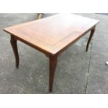 An extending mahogany dining table with panelled rectangular top having spare leaf, raised on square