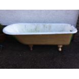 A Victorian cast iron roll-top bath raised on fluted claw feet - used as a garden flower tub. (