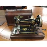 A Victorian oak cased Singer sewing machine, the domed box with ribbed handle, the cast iron working