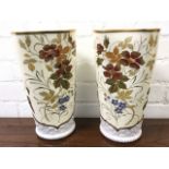 A pair of late nineteenth century porcelain vases of waisted shape enamelled with flowers & leaves