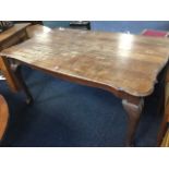 A mahogany dining table with rectangular scalloped top on shaped aprons, raised on cabriole legs
