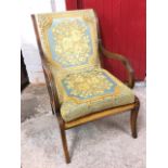 A Strongbow mahogany easy chair with moulded scrolled arms above a webbed seat with loose cushion,