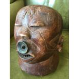 A Chokwe carved tribal head, formed from a single trunk, the mouth pierced beneath circular lip