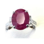 An 18ct white gold ruby & diamond ring, the large oval claw set ruby weighing just under three-and-