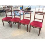 A set of four late Victorian mahogany dining chairs, the arched backs with scrolled carving above
