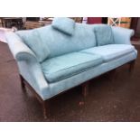 A Chippendale style camelback sofa upholstered in blue damask with loose cushions and scrolled
