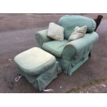 An upholstered armchair and poofe with loose cushions and covers, both raised on casters. (2)