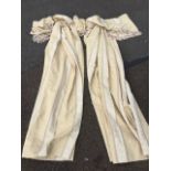 A pair of cotton lined cream coloured curtains with floral gilt bands, complete with wide tasseled