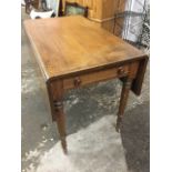 A nineteenth century oak dining table, the crossbanded top with two drop-leaves above a cockbeaded