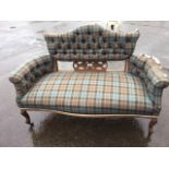 A nineteenth century sofa, the button upholstered camel back above a scroll carved pierced oak