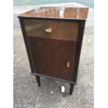 A 60s Meredew walnut bedside cupboard with frieze drawer above a door, raised on turned tapering