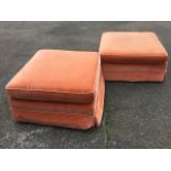 A pair of square upholstered poofs in apricot velvet, the loose cushions with cord piping, raised on