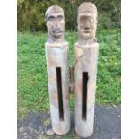 A pair of tribal drums carved from tree-trunks, the stylised heads with chisel carved crests, one