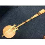 A weird wogo-wogo four stringed instrument with gourd soundbox and tapering shaft, all covered in