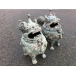 A pair of eastern bronze dogs of fo, the patinated stylised animals with hinged heads, cast with