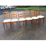 A set of six French style ladderback dining chairs, each with three shaped rails above solid seats