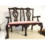 A Chippendale style carved mahogany miniature settee, the twin back with pierced leaf scrolled