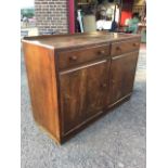 A rectangular oak utility sideboard with tray top above two drawers and two panelled cupboards,