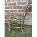 A pair of cast iron bench ends with scrolled decoration to arms, supported on channelled sabre