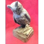 A glazed owl on book above a square canted plinth. (12.5in)