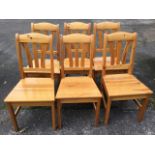 A set of six pine dining chairs, the arched back rails above shaped lats and tapering seats,