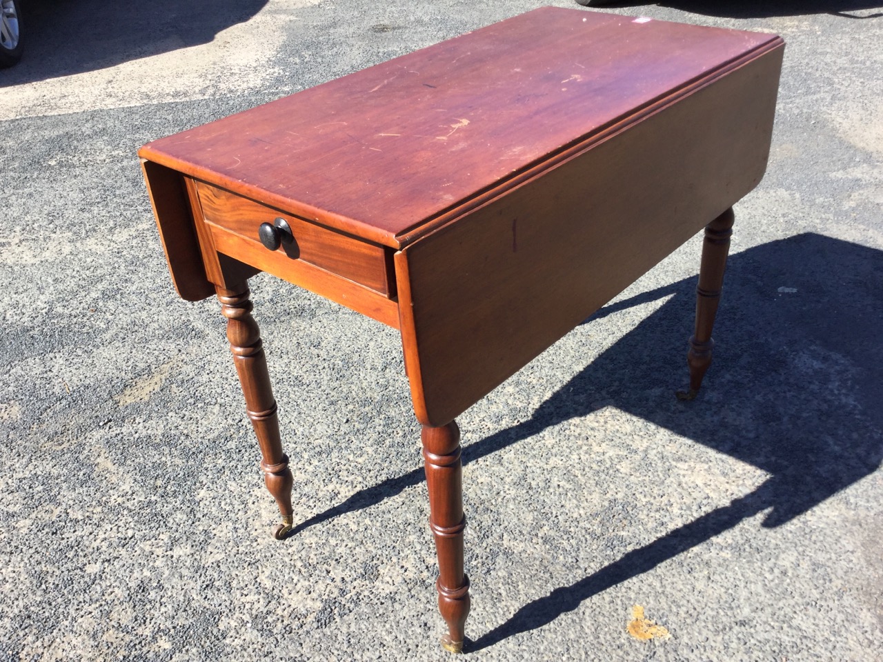 A Victorian mahogany drop-leaf table, having cockbeaded knobbed frieze drawer, raised on turned legs