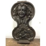 A Victorian carved oak panel, the waisted piece with eighteenth century style head above a fruit