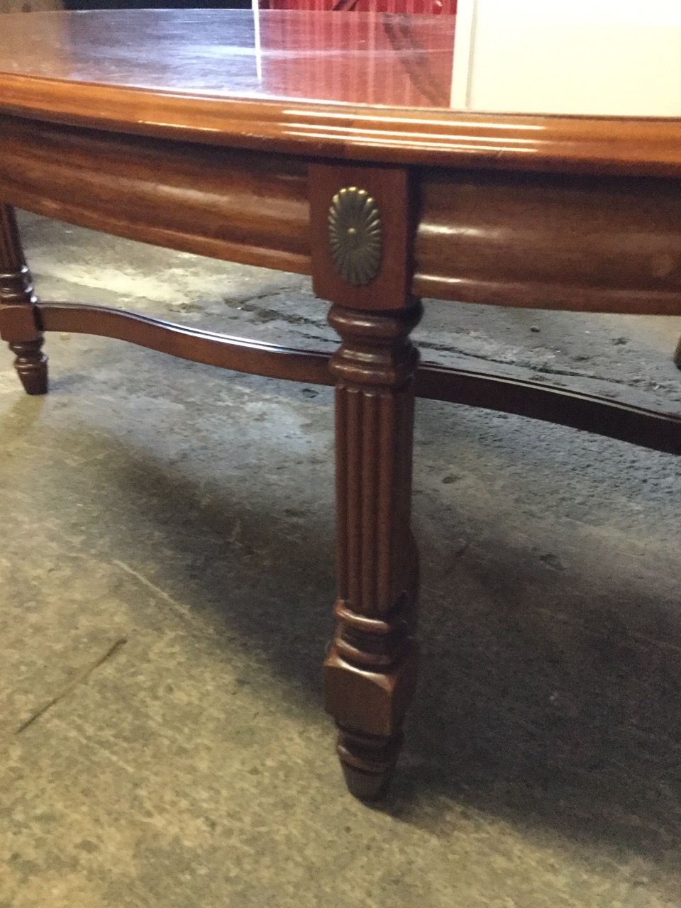 An oval reproduction mahogany coffee table, the quarter veneered crossbanded top above a moulded - Image 2 of 3