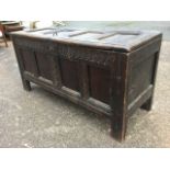 An eighteenth century oak sword chest, the four panelled box with scrolled roundel carving to