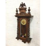 A late Victorian walnut Vienna wallclock, the crest with turned finials surmounted by an eagle,