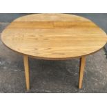 A rectangular rounded dining table with integral folding leaf, raised on square tapering beech legs.