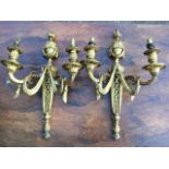 A pair of French ormolu wall sconces, the tapering pierced wallplates with urn finials, each