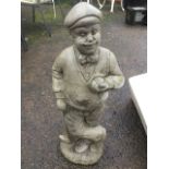 A composition stone figure of a golfer, resting on club and holding ball, raised on naturalistic