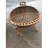 An oval cast iron fire basket, with ring crest and shell shaped back having pierced graduated rim,