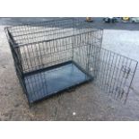 A boxed dog cage with tray base, the rectangular case with mesh panels and hinged door, folding with