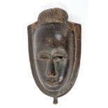 Early 20th century Dan carved wooden mask, narrowed rim eyes and angular features,