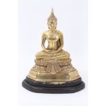 20th Century Chinese brass buddha in serene seated pose on wooden base,