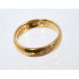 22ct gold wedding ring, set with a diagonal band of four brilliant cut diamonds.